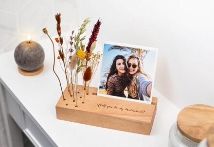 Vierkante fotoafdrukken in gegraveerde houten blok met droogbloemen